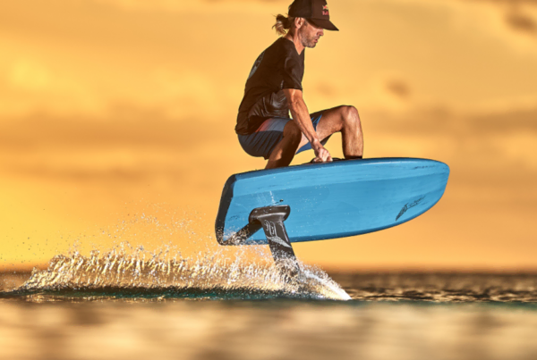 eFoiler op een blauw Lift eFoil-board komt los van het water in het avondlicht