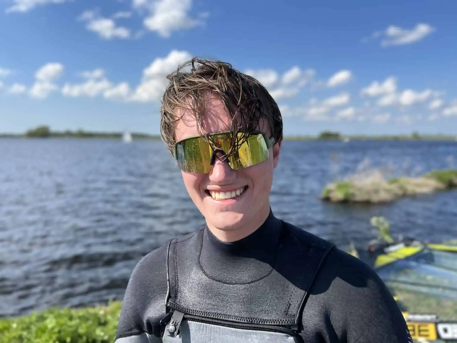 Deelnemer met zonnebril aan het water bij GearFreak Surfschool