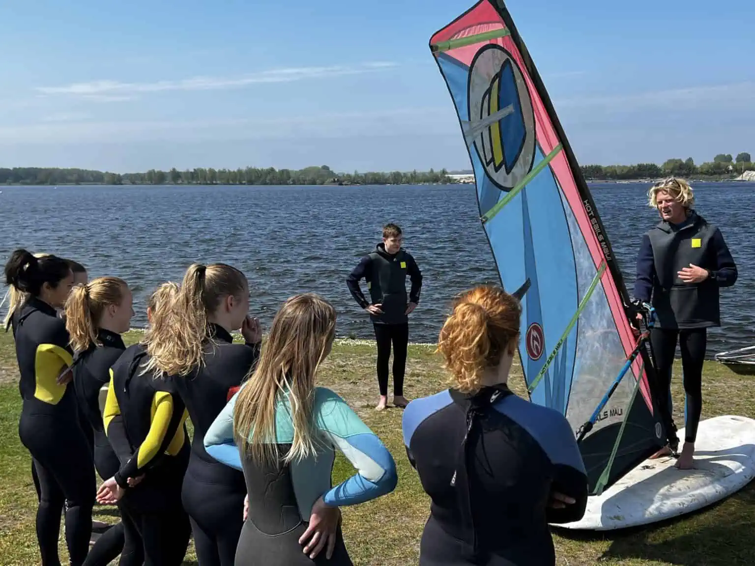 Jonge cursisten krijgen windsurfles bij GearFreak Surfschool