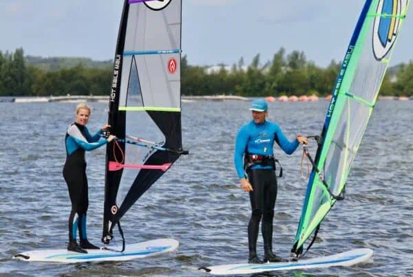 Instructeur helpt cursist met windsurfen bij GearFreak Surfschool