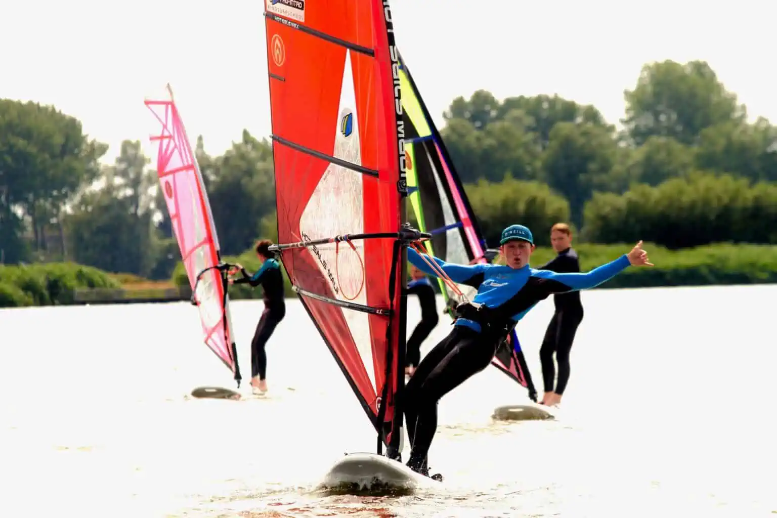 Windsurfers bij de oever van de Valkenburgse Meer bij GearFreak Surfschool