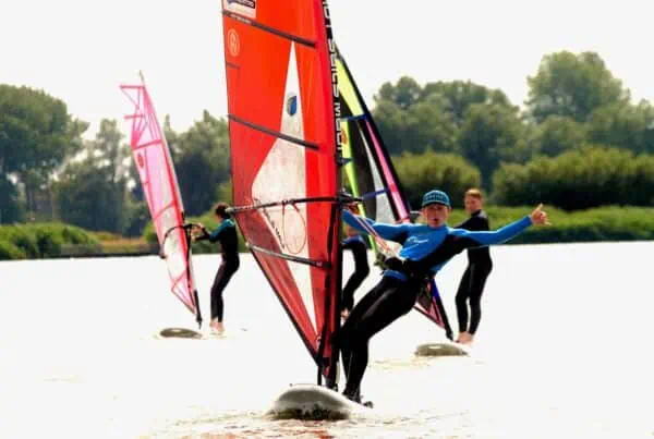 Windsurfers bij de oever van de Valkenburgse Meer bij GearFreak Surfschool