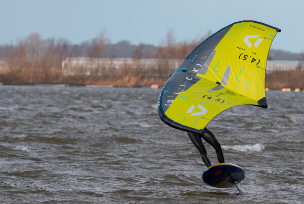Wingfoiler op de foil met een gele Duotone-wing bij harde wind op het Valkenburgse Meer